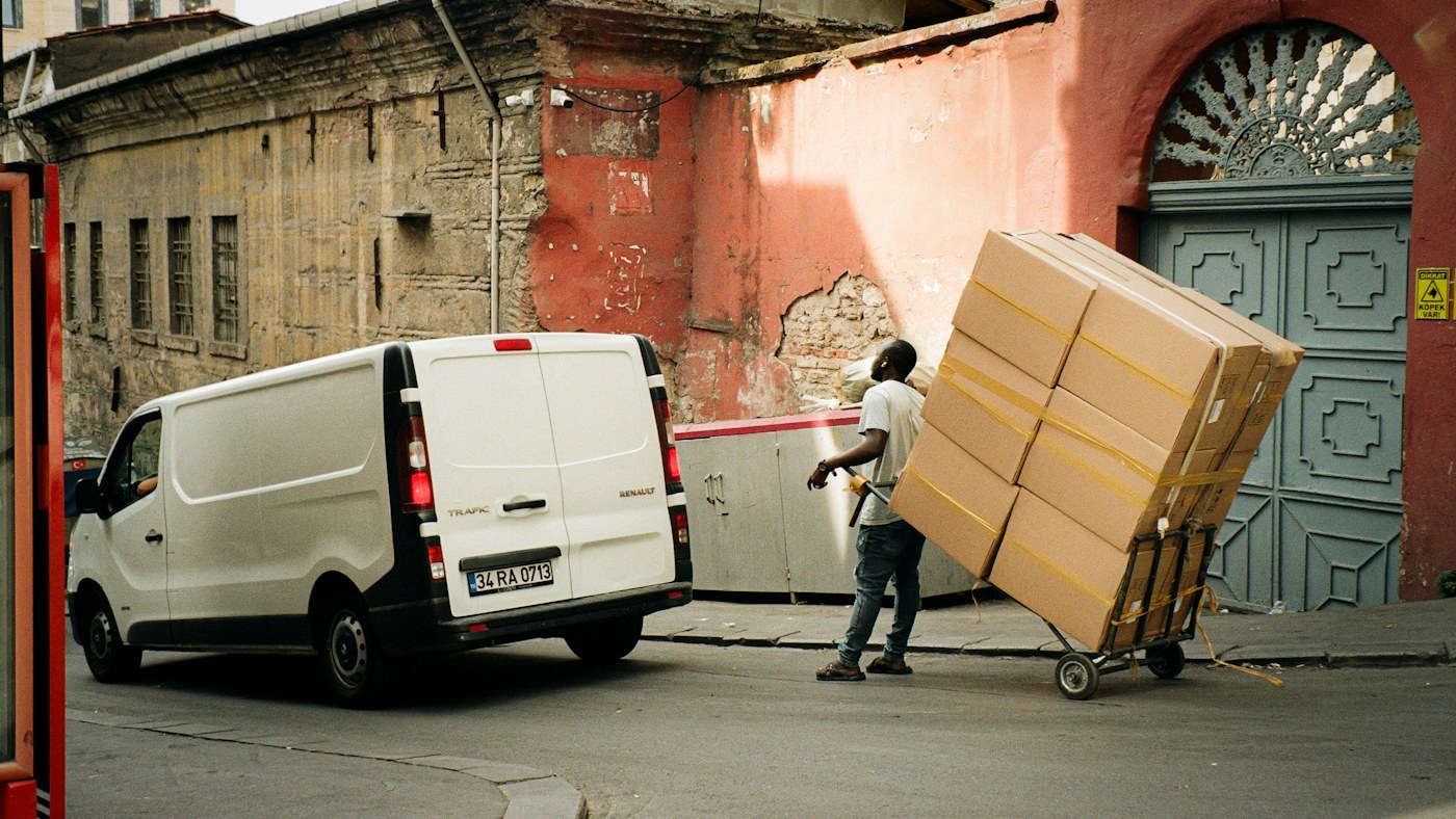 Un hombre está descargando cajas de una furgoneta