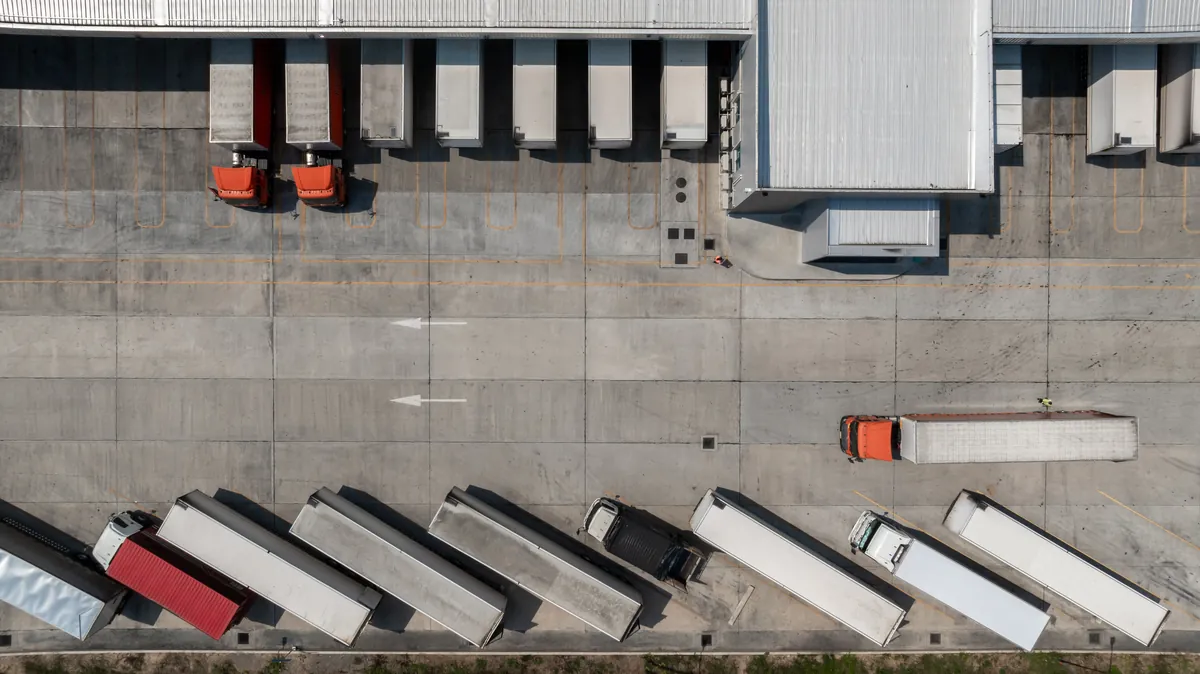 Flota de camiones en el muelle de una empresa de transporte de mercancias con tarjeta MDP
