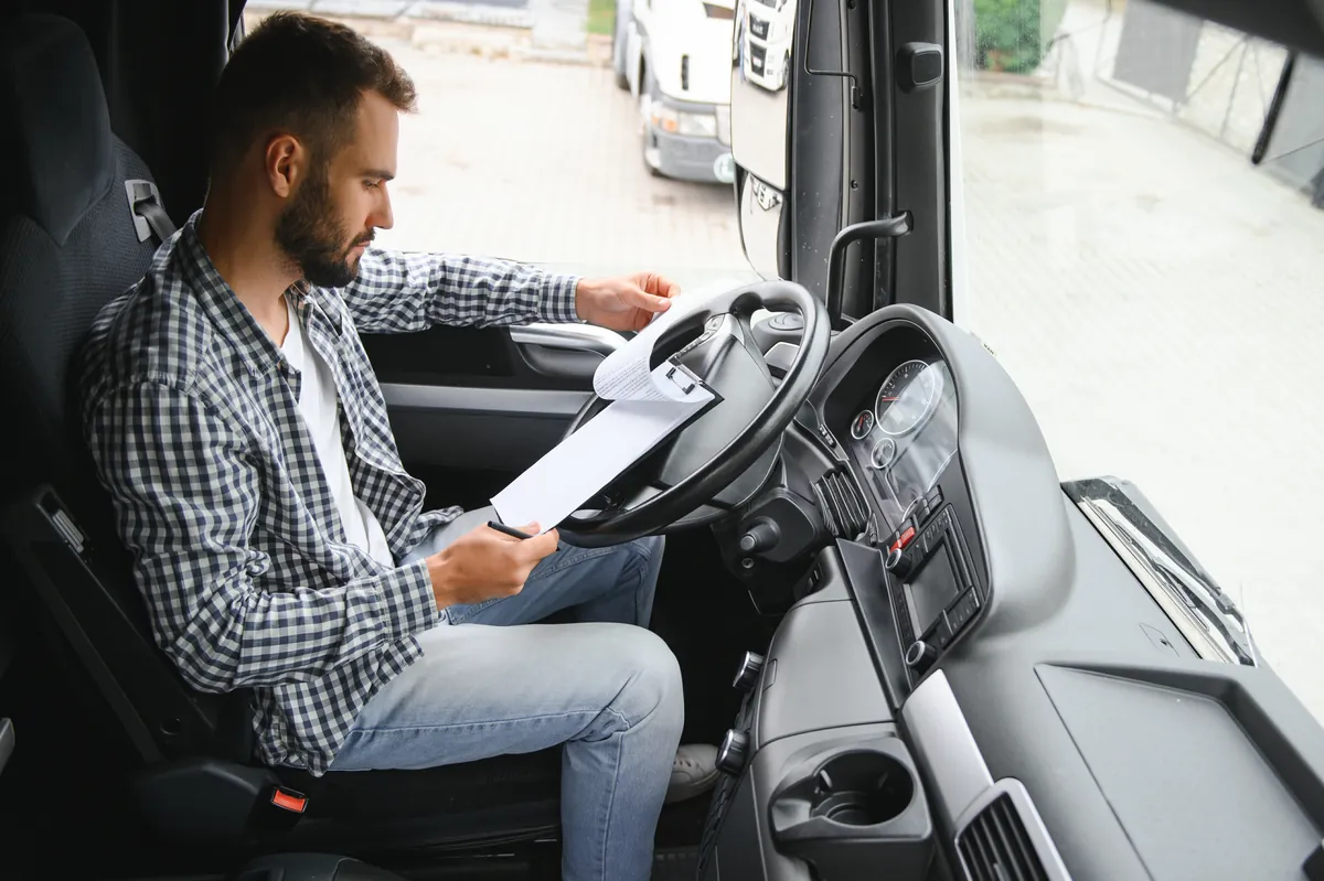 Camionero profesional revisando la documentacion necesaria para obtener la tarjeta de transporte